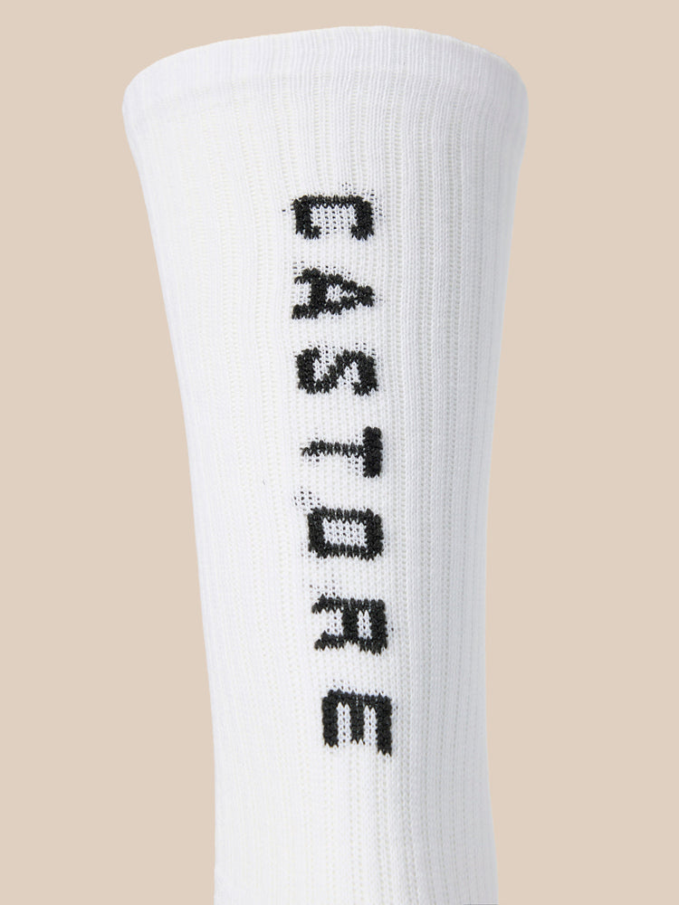 Close up of a white Paynter crew sock showing vertical Castore lettering