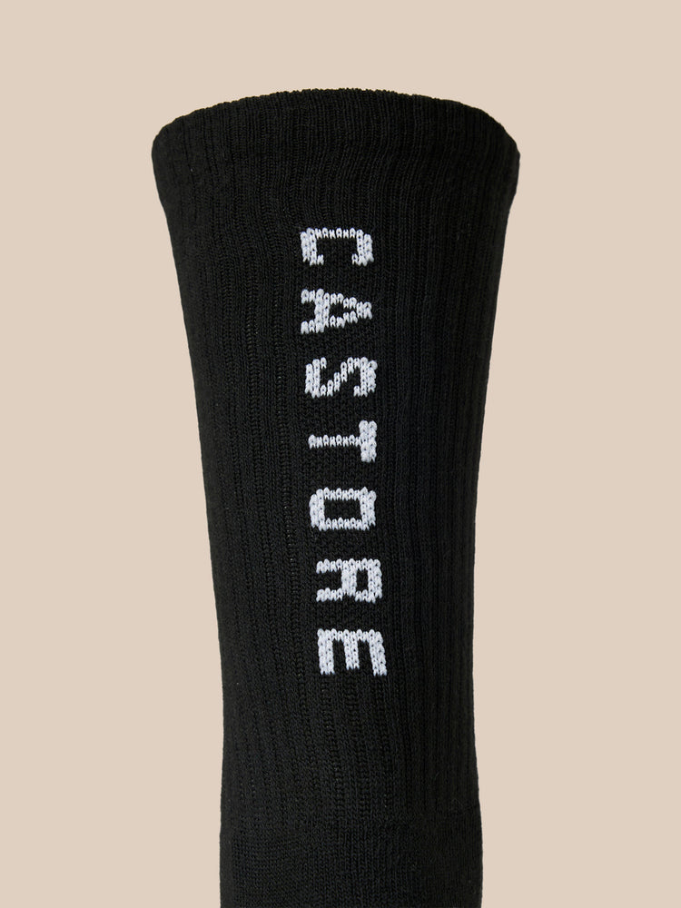 Close up of a black Castore X Ridgeway crew sock with white embroidered branding along the side