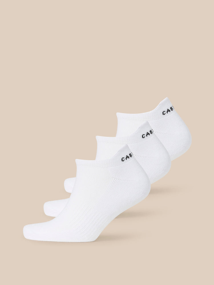White Castore X Tufnell trainer liner socks stacked diagonally in a three pack.