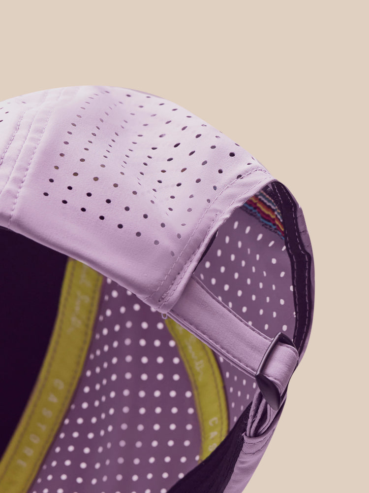 Close-up of a purple cap with a yellow interior on a beige background