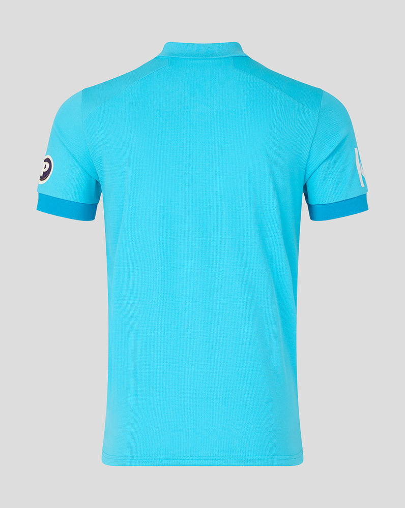 Blue polo shirt with brand logo on sleeves against a gray background