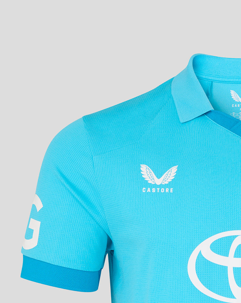 Blue polo shirt with white branding on a light gray background