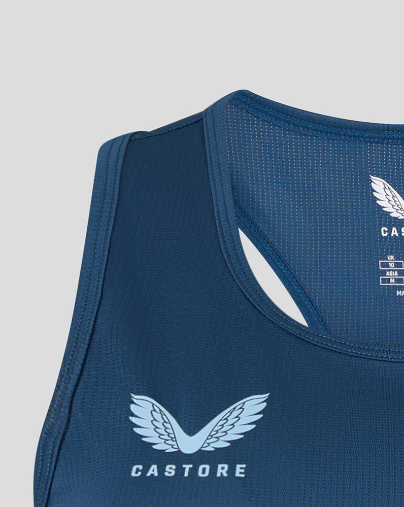 Blue athletic tank top with Castore logo on a light gray background