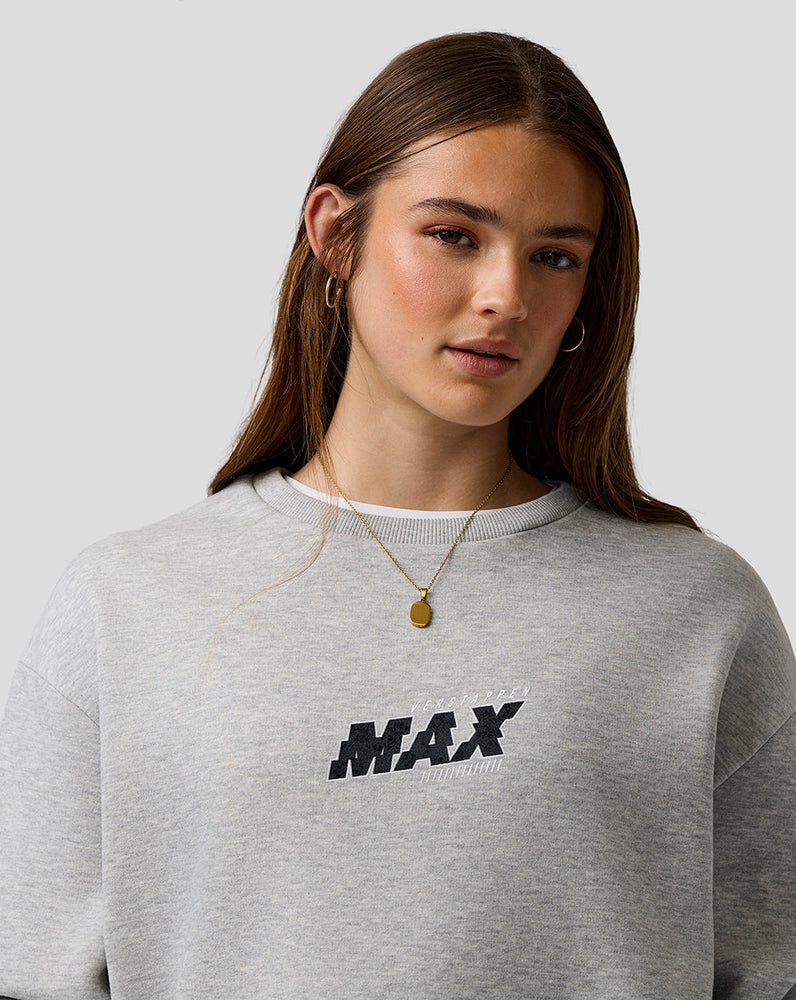 Person wearing a gray sweatshirt with 'MAX' print on a plain background